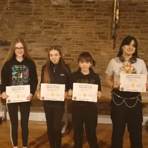 Photo of 4 young people receiving certificates of achievement